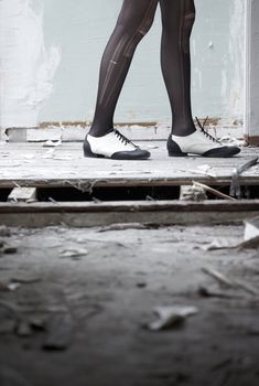 Human legs in stylish shoes standing in the ruined dirty room