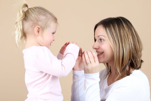 Beautiful mother and toddler daughter playing together