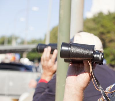 A man looking with binocular