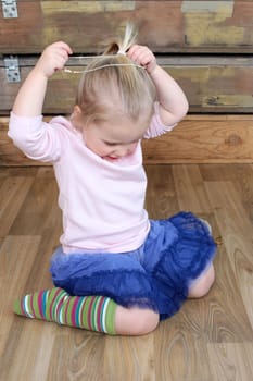 Cute little blond girl trying on jewellery