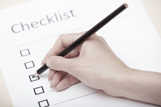 Human hand writing on a checklist document