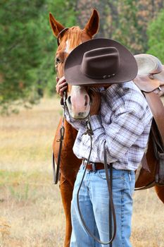 Cowboy with his horse in the field 