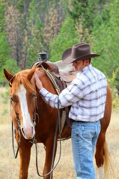Cowboy with his horse in the field 