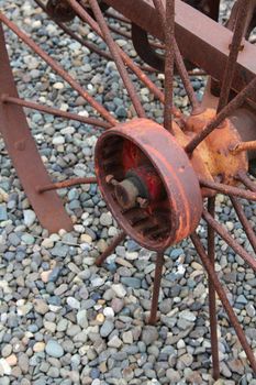 Rusted old wagon wheel in grey gravel