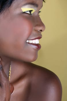 African model against yellow color background with makeup