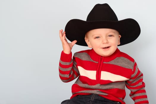 Cute blond baby wearing a red jersey against blue