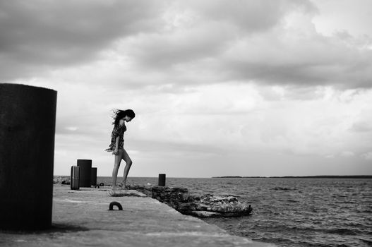 brunette woman walking at sea side.