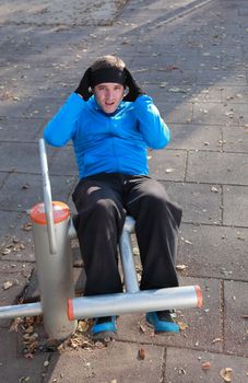 Young man doing exercise outdoors in a public park.