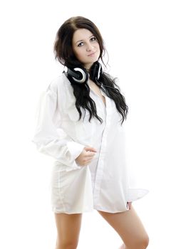 Sensual brunette girl in man's shirt with headphones. Isolated on white.