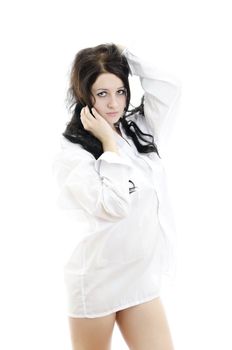 Sensual brunette girl in man's shirt touching her hair. Isolated on white.