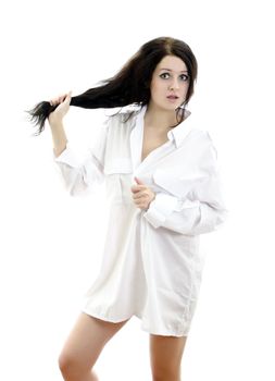 Sensual brunette girl in man's shirt touching her hair. Isolated on white.
