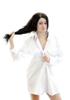Sensual brunette girl in man's shirt touching her hair. Isolated on white.