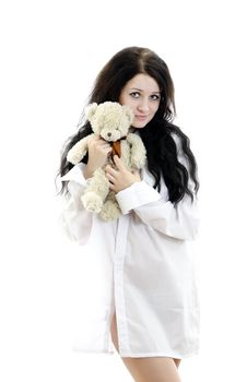 Sensual brunette girl in man's shirt with Teddy Bear. Isolated on white.
