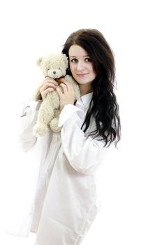 Sensual brunette girl in man's shirt with Teddy Bear. Isolated on white.