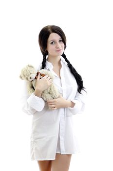 Sensual brunette girl in man's shirt with Teddy Bear. Isolated on white.