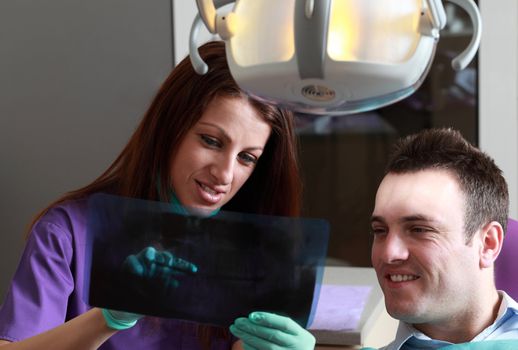 A dentist explaining to the patient a radiography.