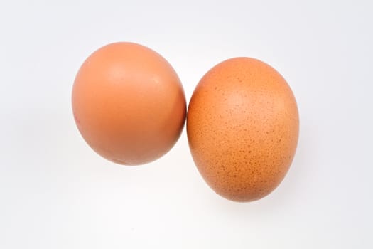 two whole brown eggs isolated on white background