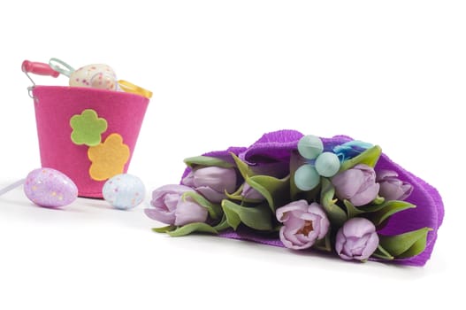 Easter eggs with bucket and tulips isolated on white