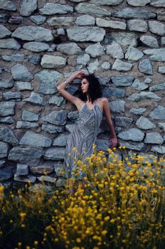 Sexy Woman Against Old Stone Wall, long distance portrait with copyspace.