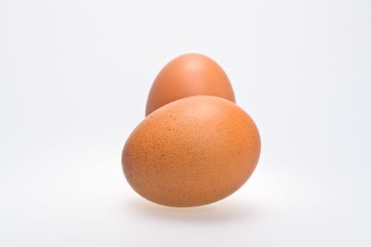 two whole brown eggs isolated on white background in landscape orientation