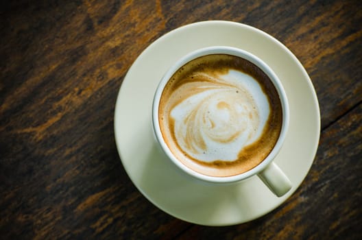 Top view of ceramic cup of coffee on wood table