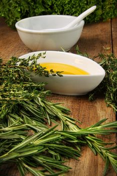 Assorted fresh herbs with olive oil on wood table