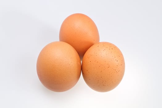 Three brown eggs isolated on white surface