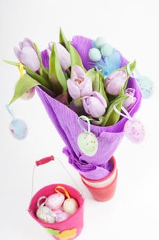Easter eggs with bucket and tulips top view