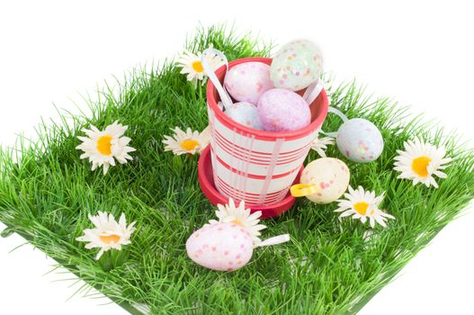 Easter eggs on the green grass and flowerpot isolated on white