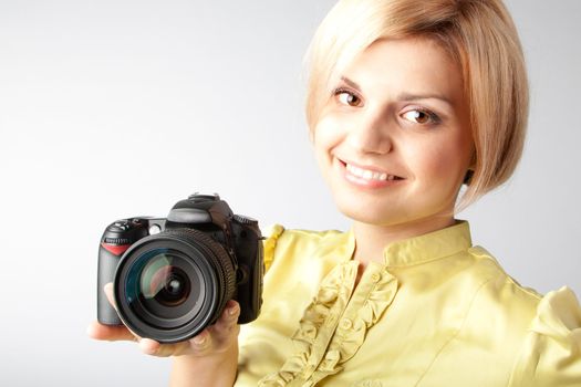 Young and beautiful girl with a professional camera in hand