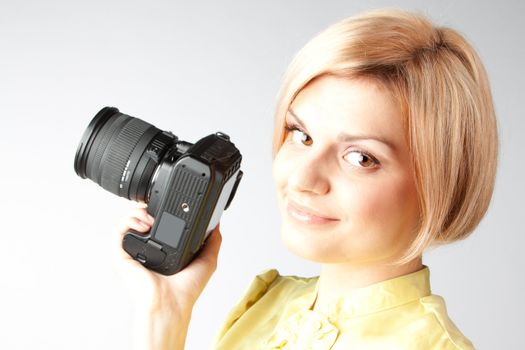 Young and beautiful girl with a professional camera in hand
