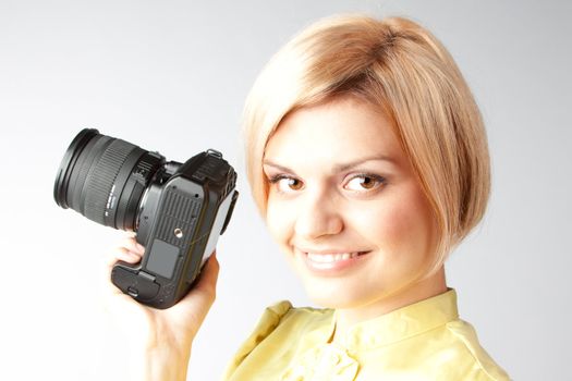 Young and beautiful girl with a professional camera in hand