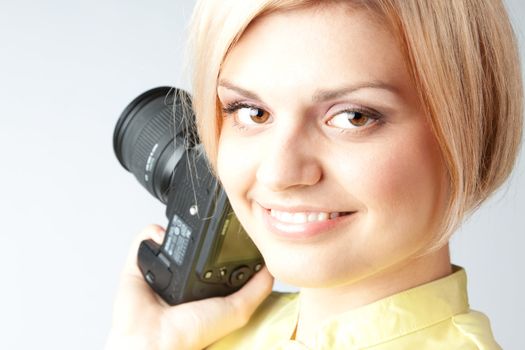 Young and beautiful girl with a professional camera in hand