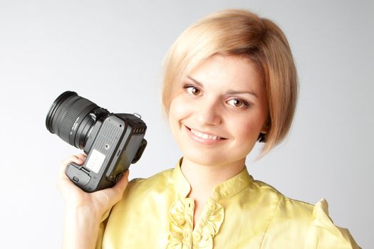 Young and beautiful girl with a professional camera in hand