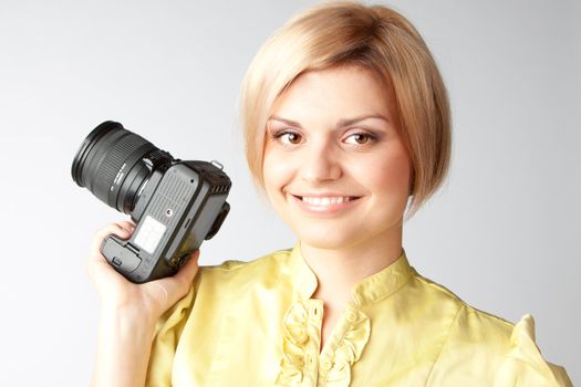 Young and beautiful girl with a professional camera in hand