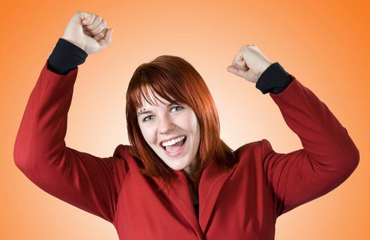 Redhead girl in red business dress rejoicing a win.
