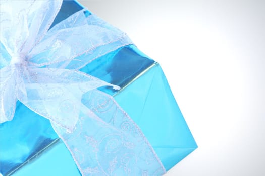 Elegant sky blue colored present with silver ribbons and bow isolated on white.