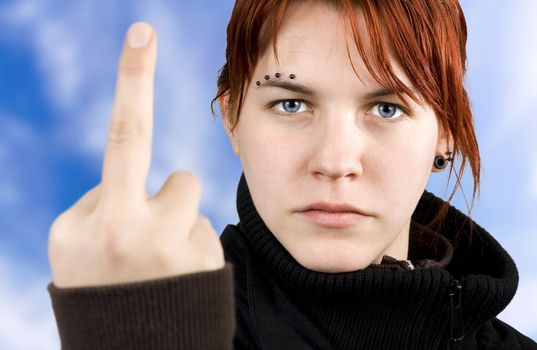 Angry redhead girl showing middle finger.