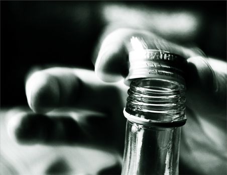 The image of a hand opening a bottle