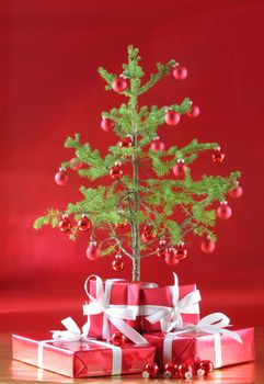 Elegant red presents under Christmas tree with deep rich red background.