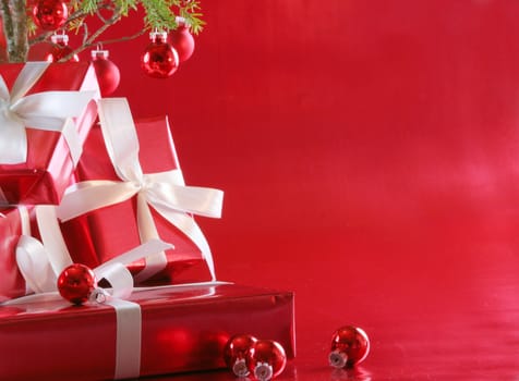 Elegant red presents under Christmas tree with deep rich red background.