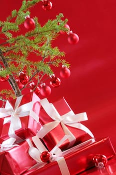 Elegant red presents under Christmas tree with deep rich red background.