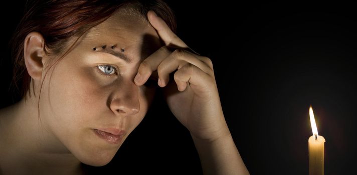 Pensive girl holding her head. Lit with two off-camera goboed flashes.