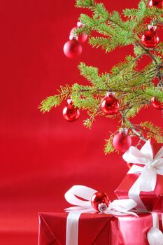 Elegant red presents under Christmas tree with deep rich red background.