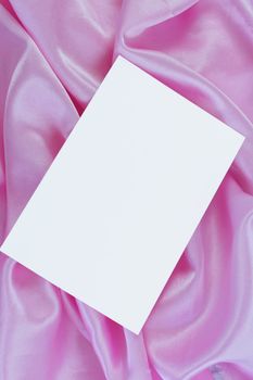 White blank card on pink satin