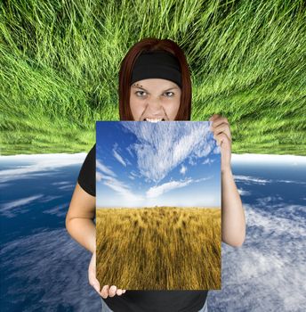 Redhead girl holding a nature canvas suitable for travel concepts.

Shot in studio. Composite background.