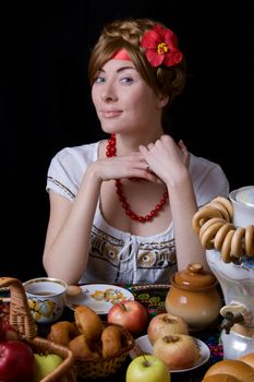 Russian woman drinking tea with samovar on black