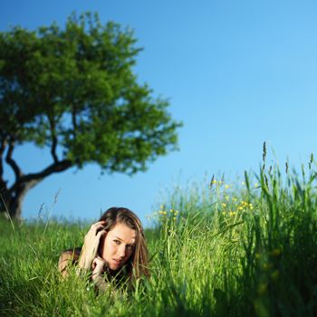  brunette lays under the tree 