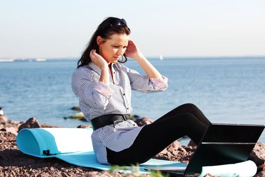 woman work on laptop sea on background