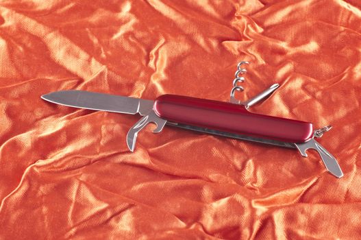 Pocket knife on beautiful red fabric